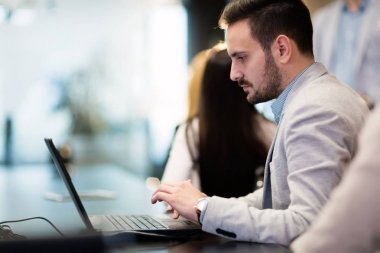 Şirket ofisindeki laptop çalışma çekici genç işadamı