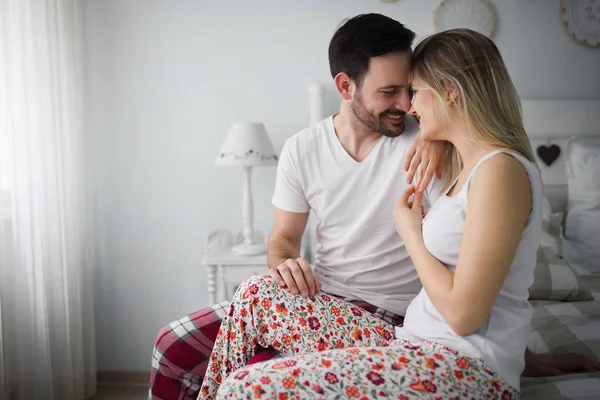 Attraktive paar küssen auf bett — Stockfoto