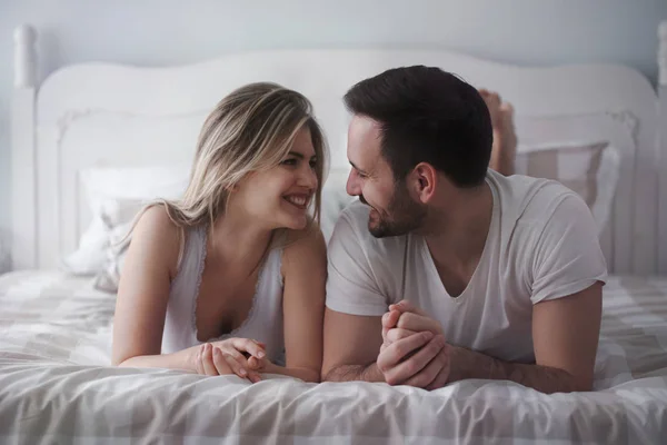 Frau und attraktiver Mann liegen auf dem Bett — Stockfoto