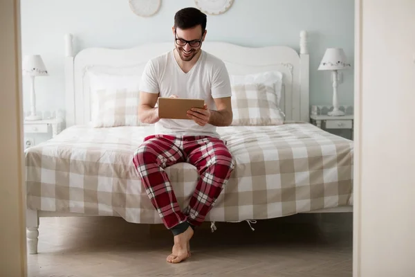 Hombre usando tableta en el dormitorio — Foto de Stock