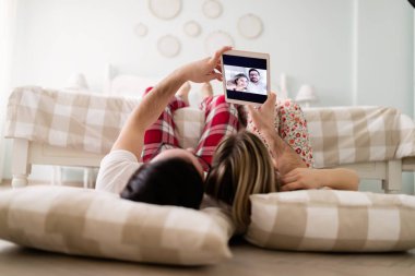 Yatak odasında tablet kullanan çift