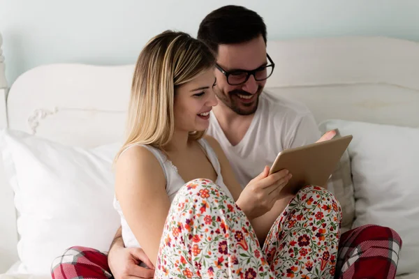 Pár pomocí tablet v ložnici — Stock fotografie