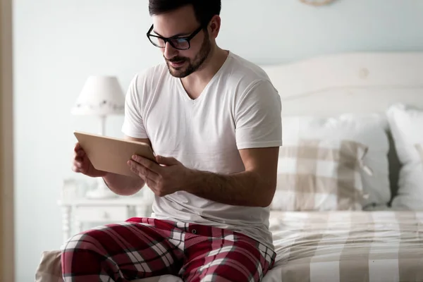 Hombre usando tableta digital en la cama — Foto de Stock