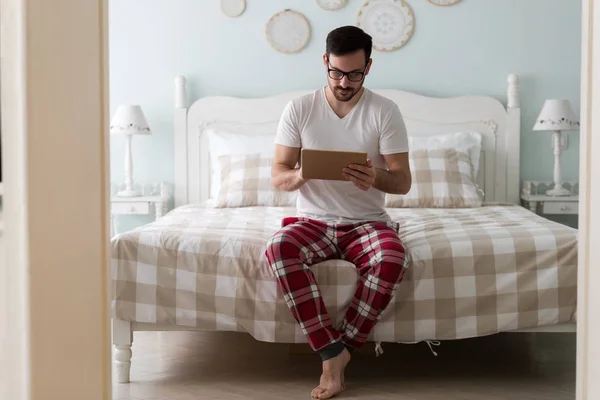 Hombre usando tableta digital en la cama — Foto de Stock