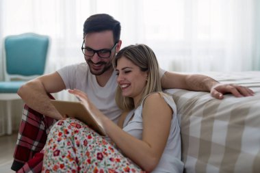  Yatak odasında tablet kullanan çift