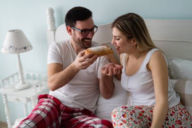  Çift yatakta kahvaltı yapıyor.