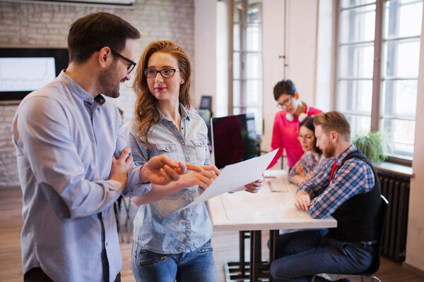 Портрет двух молодых перспективных дизайнеров, обсуждающих схему проекта
