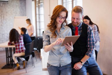 Konuşmak ve Office dijital tablet bakarak genç çekici tasarımcılar