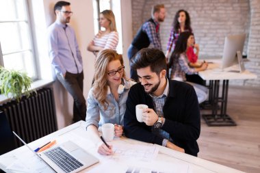 İş arkadaşları yeni fikirleri tartışıyor ve modern bir ofiste beyin fırtınası yapıyorlar.