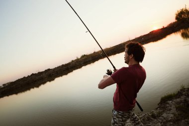 göl günbatımı sırasında balıkçı