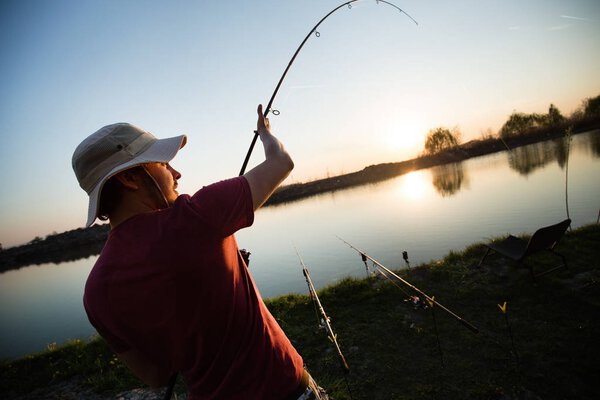 Young man fishing at pond