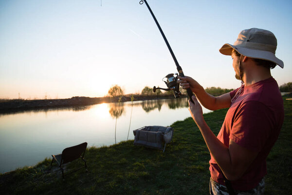fisherman at lake during sunset