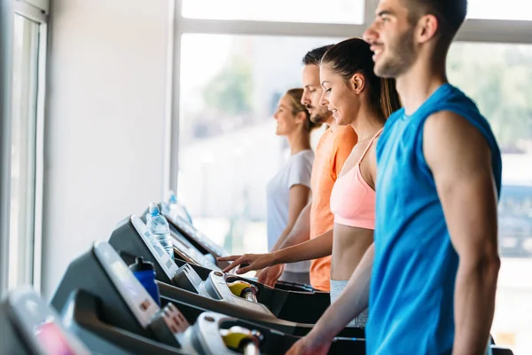 Amigos haciendo ejercicio en la máquina de cinta de correr — Foto de Stock