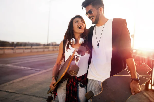 Attractive couple carrying skateboards — Stock Photo, Image