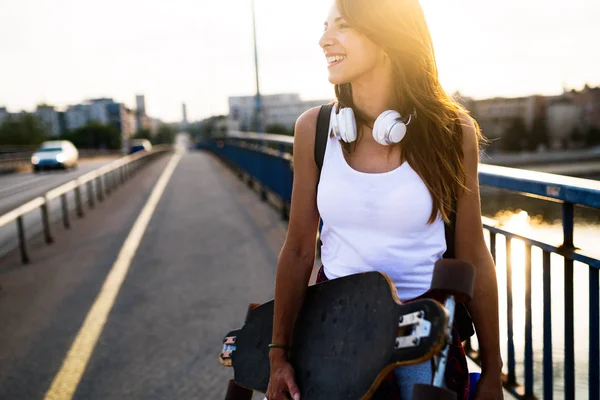 Χαμογελαστό κορίτσι που μεταφέρουν skateboard — Φωτογραφία Αρχείου