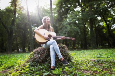 Güzel kadın doğada gitar çalmak