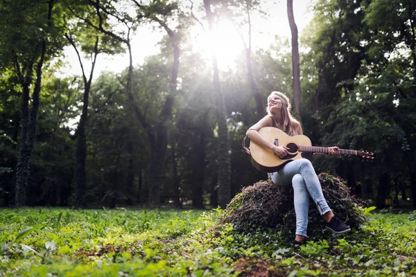 Güzel kadın doğada gitar çalmak