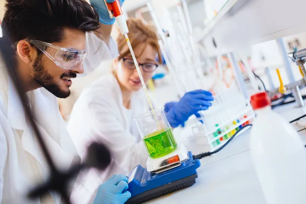 Young students of chemistry working in laboratory — Stock Photo, Image