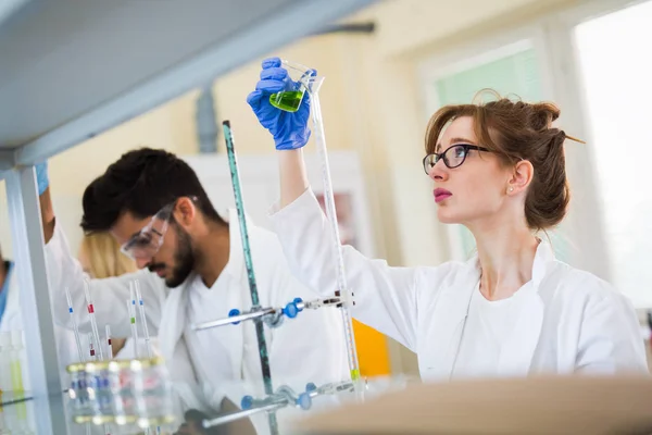 Jóvenes estudiantes de química trabajando en laboratorio — Foto de Stock