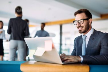 Genç yakışıklı mimar ofis içinde laptop üzerinde çalışıyor