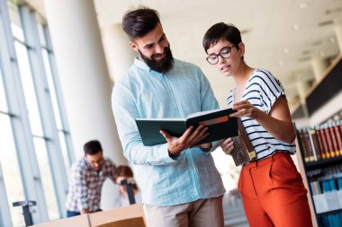 Genç çekici öğrenci üniversite kitaplığında vakit