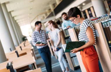 Genç çekici öğrenci üniversite kitaplığında vakit