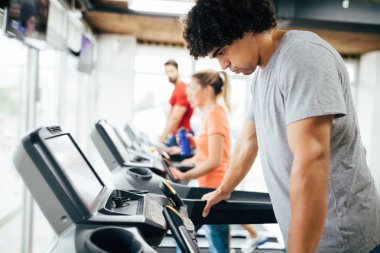Yakışıklı delikanlı kardiyo eğitim salonunda treadmill yapıyor