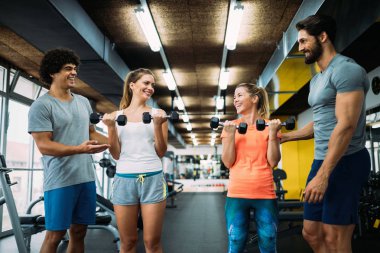 Genç güzel kadın spor salonunda kişisel eğitmenler ile yapıyor