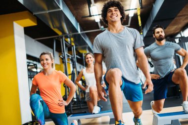 Bir grup genç insan birlikte spor salonunda yapıyor