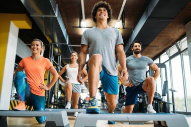 Bir grup genç insan birlikte spor salonunda yapıyor