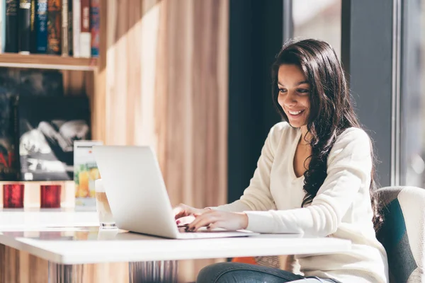 Brunetka korzysta z laptopa w kawiarni — Zdjęcie stockowe