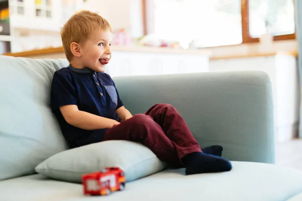 Mutlu çocuk oturma odasında kanepede oturan — Stok fotoğraf
