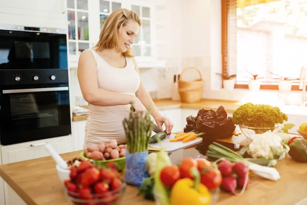 Mujer embarazada haciendo una comida en la cocina —  Fotos de Stock