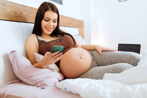Беременная женщина по телефону — стоковое фото