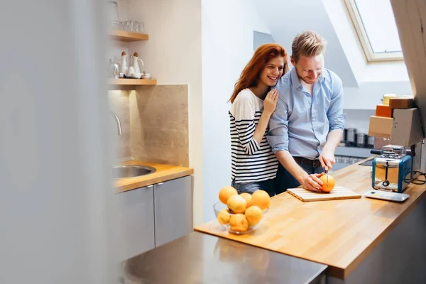 Pareja haciendo batido de naranja en la cocina —  Fotos de Stock