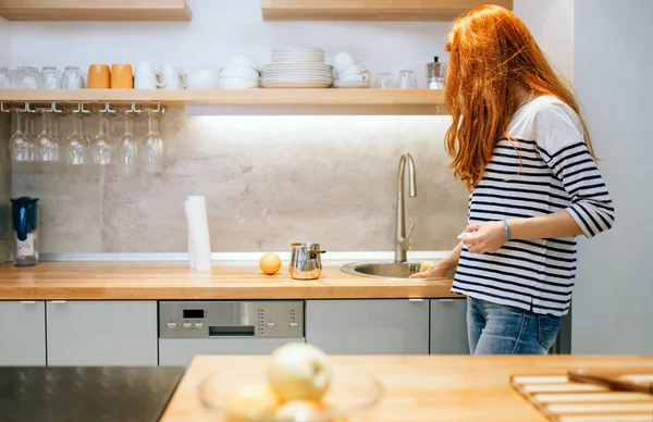 Mujer manteniendo la cocina ordenada y limpia —  Fotos de Stock