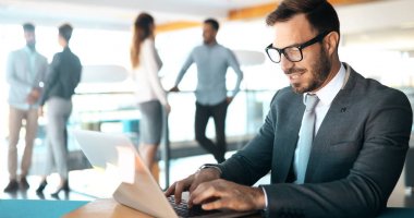 Laptopin iş office kullanarak profesyonel yakışıklı işadamı