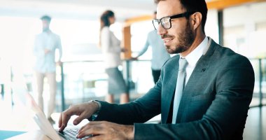 Laptopin iş office kullanarak profesyonel yakışıklı işadamı