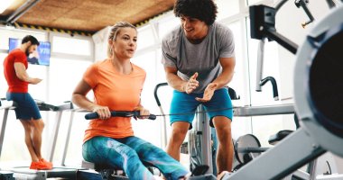 Spor salonunda özel antrenör öğrenciye talimat veriyor.
