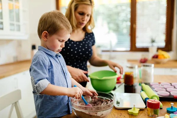 Ребенок помогает матери делать печенье — стоковое фото