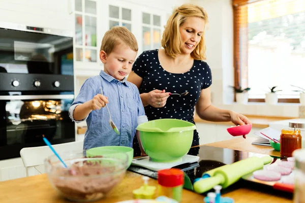Ребенок помогает матери делать печенье — стоковое фото