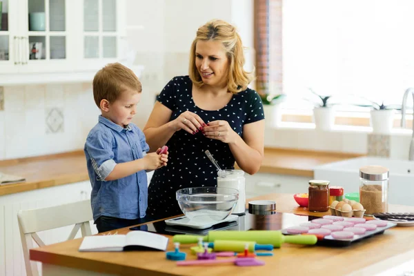 Dítě pomáhá matce připravit muffiny — Stock fotografie