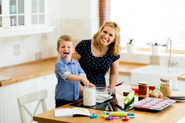 Dítě pomáhá matce připravit muffiny — Stock fotografie