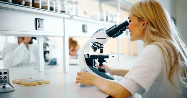 Jovem cientista olhando através do microscópio — Fotografia de Stock