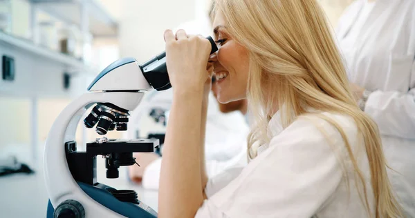Jeune scientifique regardant à travers le microscope — Photo