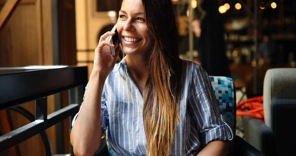 Женщина разговаривает по телефону в ресторане — стоковое фото