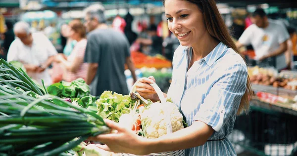 Imagem de uma mulher no mercado a comprar legumes — Fotografia de Stock