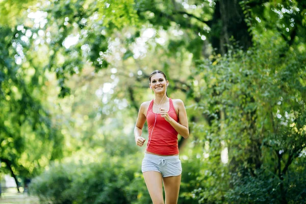 Schöne junge Joggerin im Park — Stockfoto