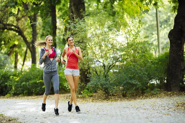 Dos mujeres deportistas corriendo en la ciudad — Foto de Stock