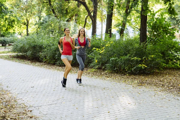 Dos mujeres deportistas corriendo en la ciudad — Foto de Stock